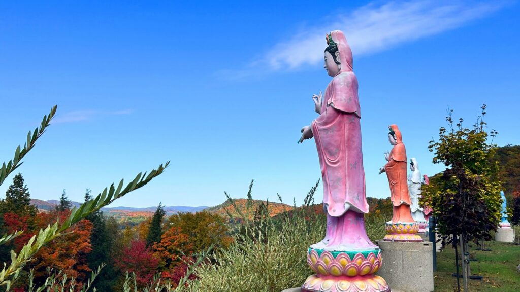 Bouddhas au sommet du monastère Tam Bao Son, face à la forêt des Laurentides